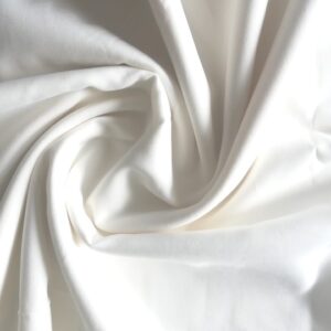 Close-up view of 100% organic cotton poplin fabric with a light to rigid drape in a slightly ecru white color.
