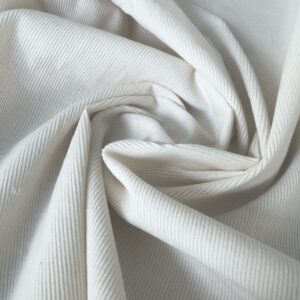 Close-up view of soft, organic cotton corduroy fabric with a classic 16 wale texture in a slightly ecru white color.