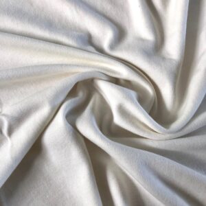 Close-up view of soft, knitted organic cotton interlock fabric showcasing its smooth texture and slightly ecru white color.