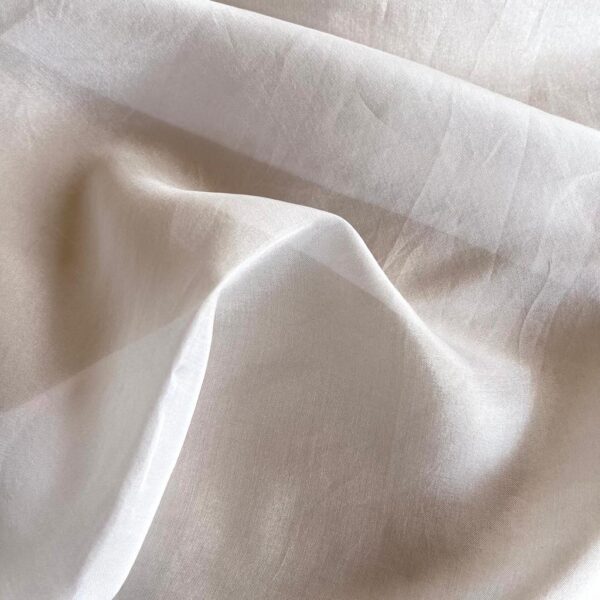 Close-up view of 100% mulberry silk Tabby silk chiffon fabric with a very light weight, gossamer soft texture, and a delicate drape in white.